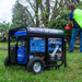 the DuroMax 13000 Watt Dual Fuel Portable HX Generator w/ CO Alert powering a chainsaw outside