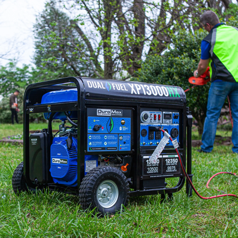 the DuroMax 13000 Watt Dual Fuel Portable HX Generator w/ CO Alert powering a chainsaw outside